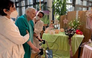 Mit Hilfe von Kathinka Siebert von der Physiotherapie-Praxis Beck & Kollegen (rechts) und Pflegerin Alma Mihmic (links) unternimmt Heim-Bewohnerin Ingeborg Wachtel ihre ersten Schritte im Caritas Altenzentrum.