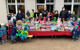 Kinder des St. Nikolaus-Kindergartens inmitten der Weihnachtsgeschenke