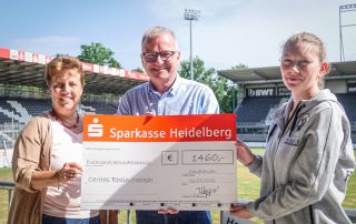 Sabine Dumat-Gehrlein und Bernhard Martin vom Caritasverband erhalten den symbolischen Scheck von Juliane Hoppart vom SV Sandhausen (Quelle: SVS)