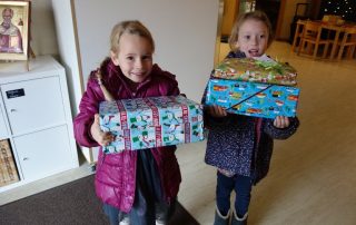 Zwei Mädchen aus dem Kindergarten St. Nikolaus in Rettigheim helfen bei der Übergabe der Weihnachtsgeschenke