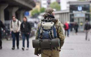 Obdachloser Mann mit Rucksack von hinten