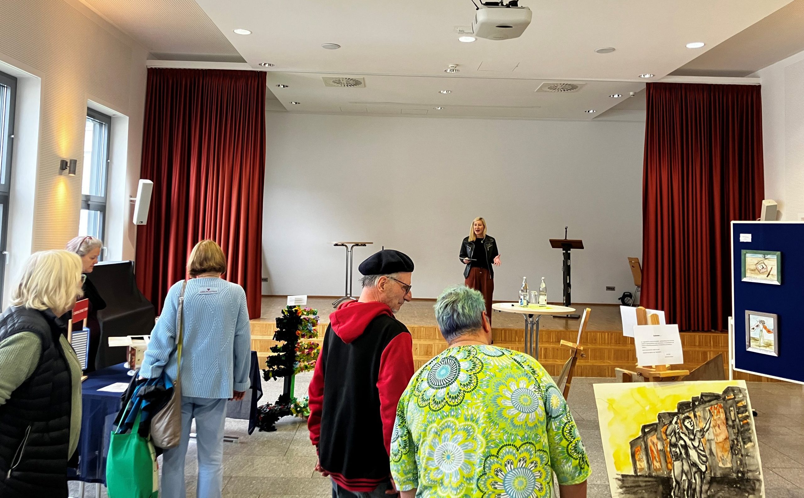 Caritas-Referatsleiterin Katrin Dolle begrüßt die Ausstellungsgäste